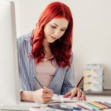 Woman coloring in adult coloring book looking happy